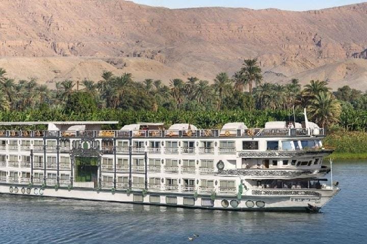 Crucero por el Nilo con montañas al fondo.