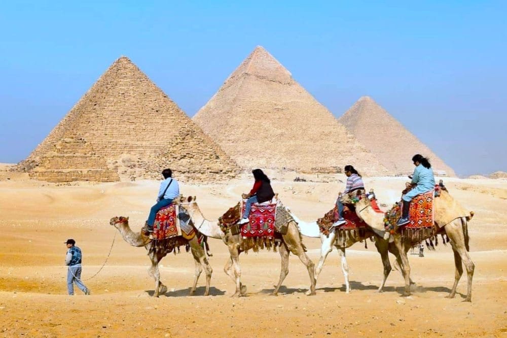 Turistas por el desierto en las pirámides de Egipto